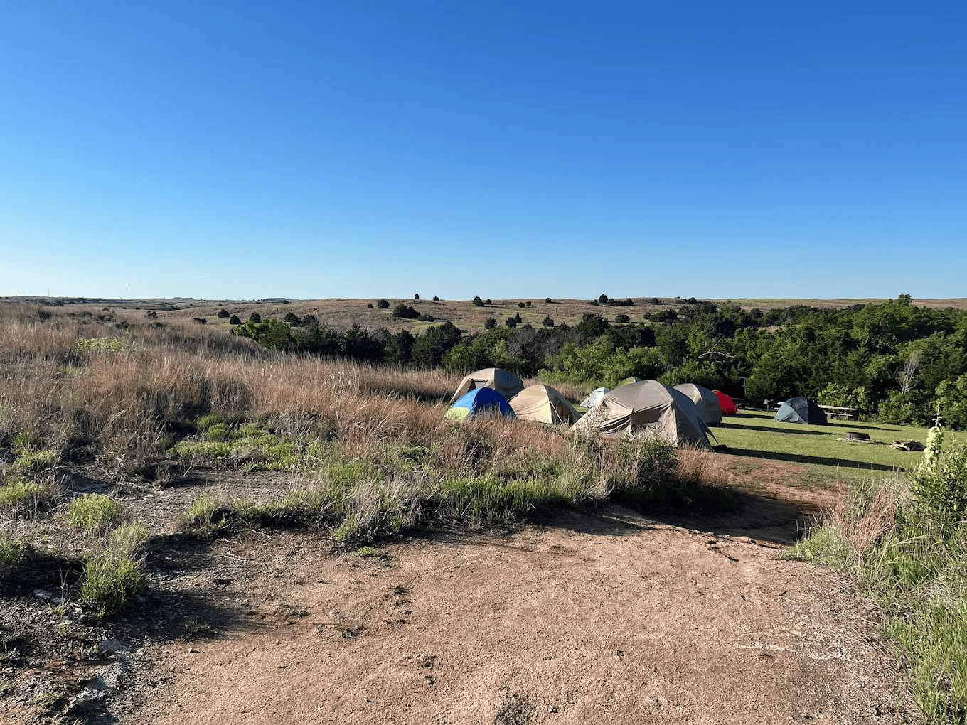 Camping tents set up in a scenic Oklahoma state park landscape.